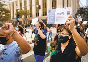  ?? Jason Armond Los Angeles Times ?? BALLOTS I N HAND, Black Lives Matter supporters march from the Hall of Justice in downtown Los Angeles to cast their votes at the Central Library. Measure J comes in response to a national reckoning on racism.