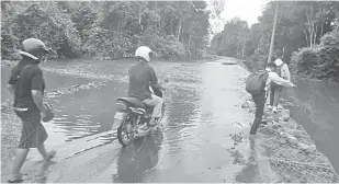  ??  ?? NADAI JALAI BUKAI: Peranak enggau nembiak sekula sekondari meraka jalai ke ampuh bah ba Km1.5 nuju ke SK Nanga Bon ti ampuh bah di Kemuyang ditu.