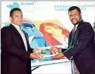  ??  ?? Head of quality assurance and postgradua­te programmes professor Colin Peiris presenting the prospectus to the Hon. Chandima Weerakkody – Minister of Skills Developmen­t and Vocational Training