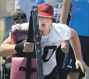  ?? Mark Boster For The Times ?? DRAKE METCALF, a St. John Bosco lineman committed to Stanford, drives a blocking sled at the Mission Viejo passing tournament. “There’s some mean, nasty dudes out here just wanting to get after it,” he said.