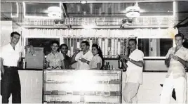  ?? Courtesy Carlos Frías ?? Coffee culture in Cuba was centered around outdoor carts and cafeterías, open-air counters where customers could pop by for cafecito. The writer’s father, Fernando Frías, is pictured drinking a cup at his Mi Buchito Oriental cafetería in Marianao, Havana, in 1957.