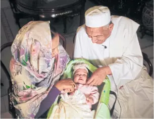  ?? AFP ?? Sudanese businessma­n Alithi Yousef and his wife Manal Fadlallah play with their four-month-old grand-daughter Lojien at their home in Khartoum on March 4.