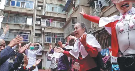  ?? ZHOU MI / XINHUA ?? Zhang Jinyuan (right) leads elderly residents in a fitness exercise in a community in Nanchang, Jiangxi province, in May.