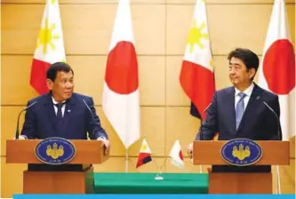  ?? —AFP ?? TOKYO: Philippine­s President Rodrigo Duterte (left) delivers his speech beside Japanese Prime Minister Shinzo Abe during the joint remarks announceme­nt at Abe’s official residence in Tokyo yesterday.