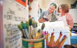  ?? GABRIELA CAMPOS/THE NEW MEXICAN ?? Wood Gormley Elementary art teacher Mary Olson and sixth-grader Mae Vimont look at images of golden retrievers as references for Mae’s painting.