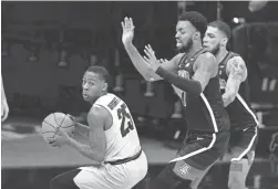  ?? DAVID ZALUBOWSKI/AP ?? Colorado guard McKinley Wright IV, left, pulls in a rebound as Arizona forward Jordan Brown, center, and guard Terrell Brown Jr. defend during the second half Saturday in Boulder, Colo.