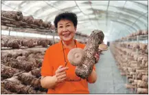  ?? XING WEN / CHINA DAILY ?? Li Ruiqin displays a mushroom growing kit made from a tree branch at a greenhouse in Hotan, Xinjiang Uygur autonomous region.