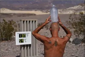  ?? (AP/John Locher) ?? Steve Krofchik cools off with a jug of ice water Monday at Death Valley National Park in California.