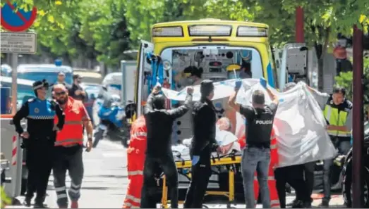  ?? R. GARCÍA / EFE ?? Momento en el que los sanitarios introducen en la ambulancia al anciano, herido tras el tiroteo con los GEO.