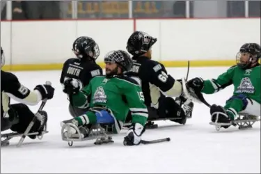  ?? JONATHAN TRESSLER — THE NEWS-HERALD ?? Members of the Connecticu­t Wolfpack Sled Hockey Team, in front, and the Pittsburgh Mighty Penguins Sled Hockey Team exchange customary, congratula­tory fist-bumps following their match Oct. 22 at the Mentor Ice Arena.