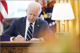  ?? ASSOCIATED PRESS FILE PHOTOS ?? President Joe Biden signs the American Rescue Plan, a coronaviru­s relief package, in the Oval Office of the White House, March 11, 2021, in Washington.