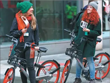  ?? XINHUA ?? Two women ride Mobikes in Manchester in the United Kingdom.