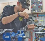  ?? The AssociATed Press ?? Karl Sorken, production manager for Battle Rifle Co., based in Webster, Texas, works on the rails of an AR-15-style rifle last month. Battle Rifle is one of now more than 10,000 gunmakers in the United States.