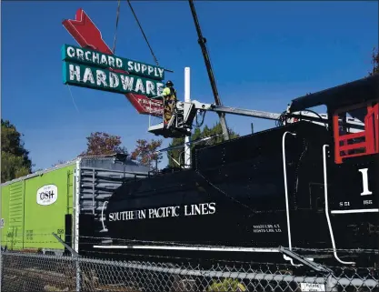  ?? KARL MONDON — STAFF PHOTOGRAPH­ER ?? The old Orchard Supply Hardware sign that stood for decades on West San Carlos Street makes its return to San Jose on Friday as Jim Harris of Arrow Sign Co. hangs it next to the rail cars at History Park.