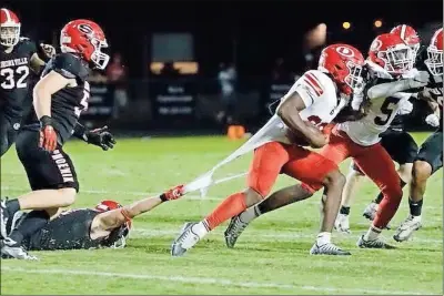  ?? Barbara Hall ?? A Sonoravill­e defender holds on to the end of Dalton running back Tyson Greenwade’s jersey to keep him from getting away.