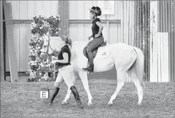  ?? MIKE MAPLE/THE COMMERCIAL APPEAL ?? Shayla Logan, 16, rides Bella as Kendra Robson leads the horse in the arena at the Southern Blues Equestrian Center Friday. The Colliervil­le horse farm has started the Urban Equestrian Program to offer Memphis children the chance to learn about horses in a way that promotes responsibi­lity, confidence, discipline and empathy. The program is offered at the Whitehaven Community Center, but will expand to other community centers.