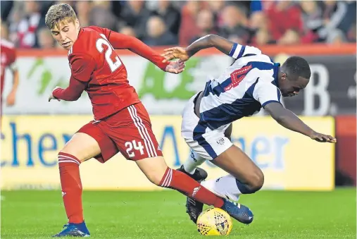  ??  ?? TOUGHT TEST: Aberdeen’s Dean Campbell, left, gets stuck in as the Reds held West Brom to a 1-1 draw at Pittodrie on Friday night