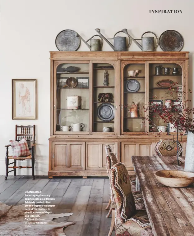  ??  ?? DINING AREA
An antique pharmacy cabinet acts as a dresser. Adelaide pasted olive green seagrass wallpaper behind the shelves to give it a sense of depth and interest.
Cabinet, Parterre.
Seagrass wallpaper,
Thibaut