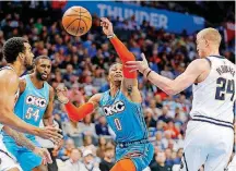  ??  ?? Oklahoma City’s Russell Westbrook (0) loses the ball as he goes between Denver’s Mason Plumlee (24) and Trey Lyles during the Thunder’s loss on Nov. 24.