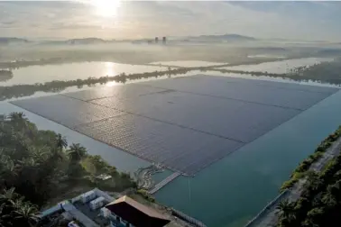  ?? AP PHOTO/VINCENT THIAN ?? The sun rises over floating solar panels May 3 in Selangor, Malaysia.