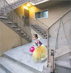  ??  ?? ANAHI PEREZ, 4, goes trick-or-treating in City Terrace. Her mother says the landlord is trying to evict them from their house.