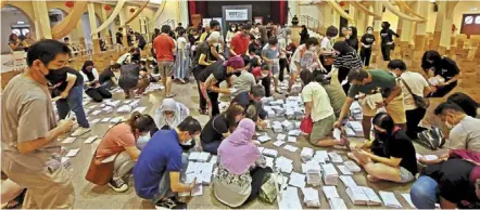  ?? ?? Many hands: volunteers arranging newly arrived postal votes at a sorting centre in Kuala Lumpur.