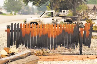  ?? Scott Strazzante / The Chronicle ?? A burned fence on Puffin Way in Redding hints at larger destructio­n from the Carr Fire.