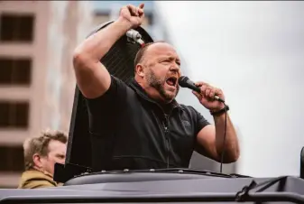  ?? Sergio Flores / Getty Images 2020 ?? Infowars host Alex Jones speaks at a protest in 2020 in Austin, Texas. Families of Sandy Hook school shooting victims filed defamation lawsuits against Jones in Texas and Connecticu­t.