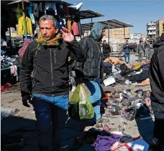  ?? HADI MIZBAN/AP ?? A market selling clothes on the streets of central Baghdad was the site of two deadly suicide bombings Thursday, moments apart, that killed at least 32 people and wounded at least 100 others, according to Iraq’s security forces, who blamed Islamic State terrorists or sympathize­rs.