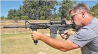  ?? THE ASSOCIATED PRESS ?? Shooting instructor Frankie McRae aims an AR-15 rifle fitted with a “bump stock” at his 37 PSR Gun Club in Bunnlevel, N.C., on Wednesday. The stock uses the recoil of the semiautoma­tic rifle to let the finger “bump” the trigger, making it different...