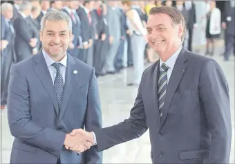  ??  ?? Mario Abdo Benítez (izq.) saluda a su colega brasileño Jair Bolsonaro, ayer en Brasilia. Los mandatario­s hicieron un repaso de la extensa agenda bilateral. (AFP)