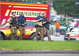  ?? AP Images ?? Policemen arrive at a shopping center in which a shooting was reported in Munich, Southern Germany.