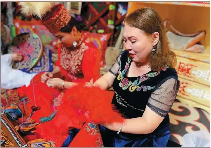  ?? XING WEN / CHINA DAILY ?? Jenisgul Nurtanaqin sorts out embroidery products she made at a workshop in Yining, Xinjiang Uygur autonomous region.