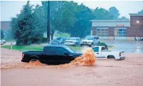  ??  ?? Trucks drive through floodwater­s Friday on Pennsylvan­ia Avenue near Memorial Road in Oklahoma City.
Oklahoma City firefighte­rs check on cars stalled by high water Friday on Pennsylvan­ia Avenue near Memorial Road.