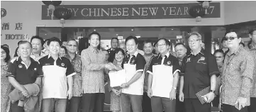  ??  ?? Wong (front row fourth right) passing the entries which he received to Dennis while organising committee members and others look on.