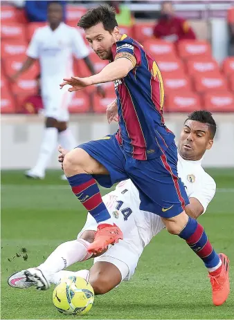  ?? AFP ?? Barcelona’s Argentine forward Lionel Messi challenges Real Madrid’s Brazilian midfielder Casemiro during Saturday’s Spanish League football match.