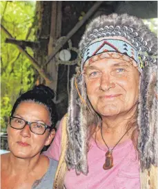  ?? FOTO: STEFAN KÜMMRITZ ?? Der Gründer, Erbauer und Leiter des Indianerki­nderdorfs „Samen“im Ulmer Ruhetal (mit Federschmu­ck) und seine Partnerin Ute, die immer mit dabei ist. Hier die beiden in der offenen Küche.