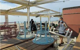  ??  ?? Workers install a terrace bar at the Barcelonet­a beach.