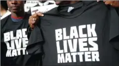  ?? NORTH AMERICA / AFP JUSTIN SULLIVAN / GETTY IMAGES ?? A protester holds a Black Lives Matter T-shirt on December 18, 2014, in San Francisco. Similar, but not identical, T-shirts and sweatshirt­s are being offered for sale on Walmart’s website.