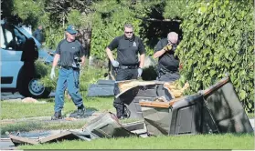  ?? MATHEW MCCARTHY WATERLOO REGION RECORD ?? Investigat­ors examine wreckage at the scene of a house explosion on Sprucedale Crescent in Kitchener on Thursday. Police say they have no suspects in Edresilda Haan’s killing.