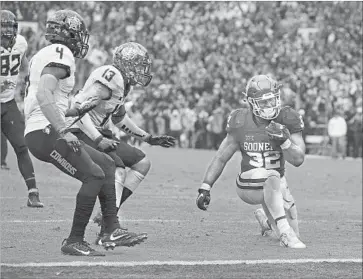  ?? Brett Deering Getty Images ?? INSTEAD OF SCORING, Oklahoma’s Samaje Perin takes a knee near the end zone in the final seconds of Saturday’s game against Oklahoma State. Perine rushed for 239 yards on a career-high 37 carries.