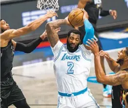  ?? COREY SIPKIN AP ?? Lakers center Andre Drummond, who finished with 20 points, grabs one of his 11 rebounds between Nets defenders Bruce Brown (left) and Lamarcus Aldridge.