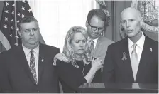  ?? THE ASSOCIATED PRESS ?? Florida Gov. Rick Scott, right, speaks Friday at a news conference before signing the Marjory Stoneman Douglas Public Safety Act at the Florida Capital in Tallahasse­e, Fla. Standing with him are, from left, Tony Montalto and wife, Jennifer, parents of...