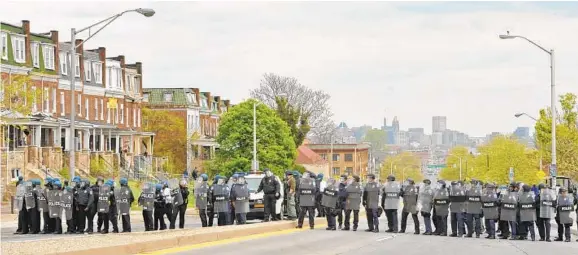  ?? AMY DAVIS/BALTIMORE SUN ?? Baltimore police officers line up near the rioting by Mondawmin Mall on April 27, 2015.