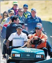  ?? Stephen Brashear
European Pressphoto Agency ?? out of a bunker by caddie Colin Swatton on his last hole at Chamber Bay, then is carted off with medical personnel. Only three shots behind the co-leaders, Day hopes to play this weekend.
