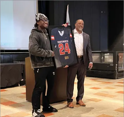  ?? PHOTO BY RYAN MENZIE ?? Former Chatsworth High football standout Rayna Stewart, right, is presented with a framed version of the No. 24jersey he wore at the school.