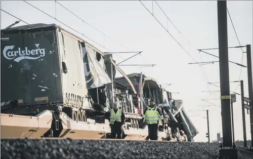  ?? PICTURE: AFP/GETTY IMAGES ?? RIPPED TARPAULIN: Damage to the Carlsberg freight train which had been carrying crates of beer across the bridge at Nyborg, Denmark.