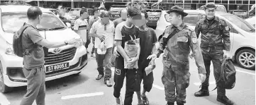  ??  ?? Some of the suspected illegal immigrants rounded up at three separate locations in Miri.