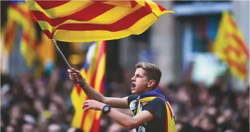  ?? PIERRE -PHILIPPE MARCOU AGENCE FRANCE-PRESSE ?? Un garçon agitant un drapeau catalan parmi la foule réunie place San Jaume. «Aujourd’hui, c’est le début de l’indépendan­ce», chantaient les manifestan­ts.