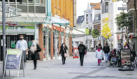  ?? Dpa-BILD: Sina Schuldt ?? Passanten mit Masken gehen durch die Innenstadt: Aufgrund des erweiterte­n Lockdowns sind die Geschäfte in Delmenhors­t weiterhin geschlosse­n. Das trifft den Einzelhand­el hart. .